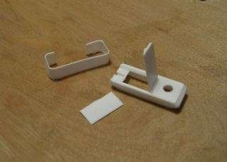 Togliere la parte superiore della scatola (quella non trasparente e con la linguetta di apertura). Tagliare circa 0,5 cm della parte inferiore e creare in quella restante un foro grande abbastanza per accomodare la piccola luce a led bianca. Incollare saldamente sotto questa parte il piccolo interruttore. 